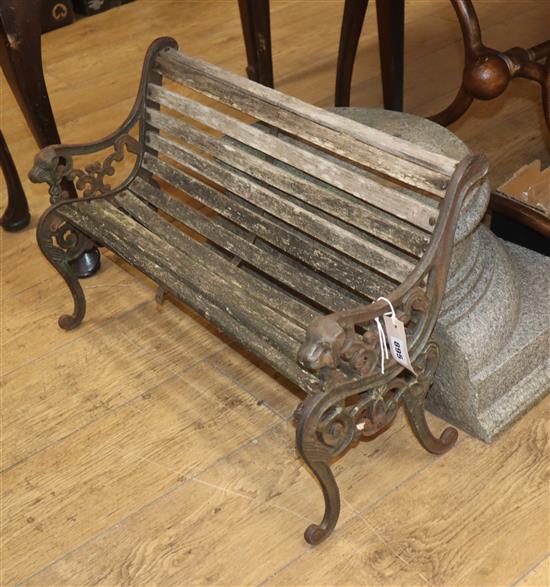 A childs Victorian style slatted wooden bench, with cast iron stand W.63cm